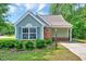 Charming single-story home featuring blue siding, brick accents, and a well-manicured lawn with green shrubs at 2 Donnelly Ct, Durham, NC 27713