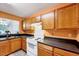 An eat-in kitchen featuring wooden cabinets and standard appliances with a large pass-through window at 2 Donnelly Ct, Durham, NC 27713