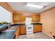 Functional kitchen with wood cabinets, black countertops, and tile flooring at 2 Donnelly Ct, Durham, NC 27713