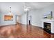 Spacious living room featuring hardwood floors, a fireplace, vaulted ceiling, and open pass-through to kitchen at 2 Donnelly Ct, Durham, NC 27713