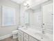 Bathroom featuring dual sinks with marble countertop, a window, and a view of the tub and toilet at 203 S South Bend Dr, Durham, NC 27713