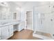 Modern bathroom featuring a double vanity, a glass shower, wood-style tile flooring, and a walk-in closet at 203 S South Bend Dr, Durham, NC 27713
