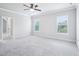 Spacious bedroom with carpet, ceiling fan, and natural light from two windows at 203 S South Bend Dr, Durham, NC 27713