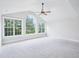 Expansive, bright bedroom featuring an arched window, neutral carpeting, and a ceiling fan at 203 S South Bend Dr, Durham, NC 27713