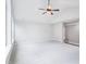 Spacious bedroom with neutral carpet, ceiling fan, white walls, and large window for natural light at 203 S South Bend Dr, Durham, NC 27713