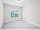 Well-lit bedroom with neutral walls and carpet, plus a window offering natural light and outdoor views at 203 S South Bend Dr, Durham, NC 27713