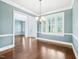 Dining area featuring hardwood floors, blue walls, and natural light through large windows at 203 S South Bend Dr, Durham, NC 27713