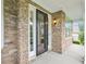 Inviting covered front porch with a stone facade, exterior lighting, and black framed glass storm door at 203 S South Bend Dr, Durham, NC 27713