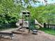 Community playground featuring slides and climbing apparatus with a park bench and treeline at 203 S South Bend Dr, Durham, NC 27713