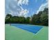 Bright blue tennis court ready for a match and surrounded by lush green trees at 203 S South Bend Dr, Durham, NC 27713