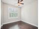Bright bedroom featuring a ceiling fan, white trim, hardwood floors and a window with plantation shutters at 203 South Bend Dr, Durham, NC 27713