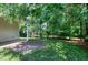 Well-maintained backyard featuring a patio, green grass and lots of mature trees at 204 Southern Style Dr, Holly Springs, NC 27540