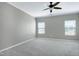 Bright bedroom with neutral carpet, two windows and ceiling fan at 204 Southern Style Dr, Holly Springs, NC 27540