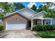 Charming brick home featuring an attached garage, well-maintained landscaping, and a cozy front porch at 204 Southern Style Dr, Holly Springs, NC 27540