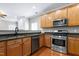 Stylish kitchen with granite countertops, wood cabinetry, and stainless steel appliances, with an open design at 204 Southern Style Dr, Holly Springs, NC 27540
