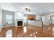 Open-concept living space with hardwood floors, a fireplace, and kitchen access at 204 Southern Style Dr, Holly Springs, NC 27540