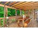 Inviting covered deck area with string lights, wooden table, and view of a lush backyard at 210 Dutchess Dr, Cary, NC 27513