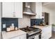 Stylish kitchen featuring a stainless steel range with hood and white cabinets at 210 Dutchess Dr, Cary, NC 27513