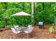 Outdoor patio with a dining table, umbrella, and grill, perfect for entertaining in a wooded setting at 210 Dutchess Dr, Cary, NC 27513