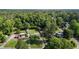 Aerial view of a property showcasing lush green surroundings, multiple buildings, solar panels and access to a wooded area at 2125 Cheek Rd, Durham, NC 27704