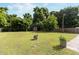 Large backyard featuring green grass, mature trees, and a storage shed at 2125 Cheek Rd, Durham, NC 27704