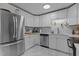 Updated kitchen with stainless steel refrigerator, white cabinets, and white tile backsplash at 2125 Cheek Rd, Durham, NC 27704
