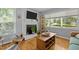 Inviting living room featuring a white brick fireplace, hardwood floors, and large windows at 2125 Cheek Rd, Durham, NC 27704