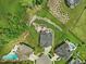 Aerial view showcasing a home's backyard oasis with patio, rock feature, and community layout with pools at 213 Lofty Oak Ln, Holly Springs, NC 27540