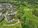 Aerial view of a neighborhood, highlighting a home's backyard with patio and golf course views at 213 Lofty Oak Ln, Holly Springs, NC 27540