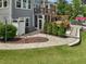 Landscaped backyard featuring a hot tub under a pergola and a stone patio area at 213 Lofty Oak Ln, Holly Springs, NC 27540