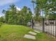 Lush backyard features manicured lawn and a stone walkway leading to a fenced outdoor area at 213 Lofty Oak Ln, Holly Springs, NC 27540