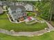 Expansive backyard with a stone patio, hot tub, fire pit, and meticulously landscaped grounds for luxurious outdoor living at 213 Lofty Oak Ln, Holly Springs, NC 27540
