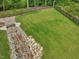 Aerial view of a spacious backyard with a stream and manicured lawn at 213 Lofty Oak Ln, Holly Springs, NC 27540