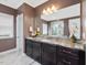 Bathroom featuring a granite countertop, dual sinks, and a large mirror at 213 Lofty Oak Ln, Holly Springs, NC 27540