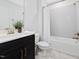 Clean bathroom features a vanity with a sleek black cabinet and a shower-tub combination at 213 Lofty Oak Ln, Holly Springs, NC 27540