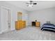Spacious bedroom with carpet, a ceiling fan, and natural wood furniture at 213 Lofty Oak Ln, Holly Springs, NC 27540