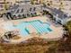 Aerial view of a community pool with multiple swimming areas, including a slide and ample parking at 213 Lofty Oak Ln, Holly Springs, NC 27540