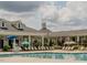 Community pool with lounge chairs, umbrellas, lifeguard stand, and clubhouse view for ultimate relaxation at 213 Lofty Oak Ln, Holly Springs, NC 27540