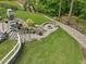 Landscaped backyard with a circular stone fire pit and seating area, perfect for gatherings at 213 Lofty Oak Ln, Holly Springs, NC 27540