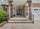 Inviting covered front porch with stone accents and comfortable seating, enhanced by a stylish double door entrance at 213 Lofty Oak Ln, Holly Springs, NC 27540