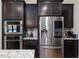 Stylish kitchen with dark cabinets, stainless steel appliances, and granite countertops at 213 Lofty Oak Ln, Holly Springs, NC 27540