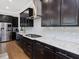Modern kitchen with white subway tile backsplash, dark cabinets, and stainless steel hood vent at 213 Lofty Oak Ln, Holly Springs, NC 27540