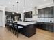 Gourmet kitchen with dark cabinets, a large island, granite countertops, and stainless steel appliances at 213 Lofty Oak Ln, Holly Springs, NC 27540