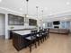 Open kitchen with a large island, dark cabinets, stainless steel appliances, and hardwood floors at 213 Lofty Oak Ln, Holly Springs, NC 27540