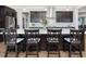 Kitchen island with granite countertops, dark cabinets, seating for four, and pendant lighting at 213 Lofty Oak Ln, Holly Springs, NC 27540