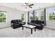 Bright living room with lots of windows and leather sofas at 213 Lofty Oak Ln, Holly Springs, NC 27540