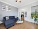 Cozy living room with a comfortable sofa, natural light, and an open entrance to the kitchen and dining area at 213 Lofty Oak Ln, Holly Springs, NC 27540