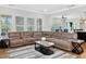 Spacious living room with a large sectional sofa, wood floors, and lots of natural light at 213 Lofty Oak Ln, Holly Springs, NC 27540