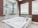 Bathroom featuring a large soaking tub with jets, walk-in shower, and marble countertops at 213 Lofty Oak Ln, Holly Springs, NC 27540