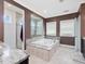 Bathroom featuring a large soaking tub, walk-in shower, and lots of natural light at 213 Lofty Oak Ln, Holly Springs, NC 27540